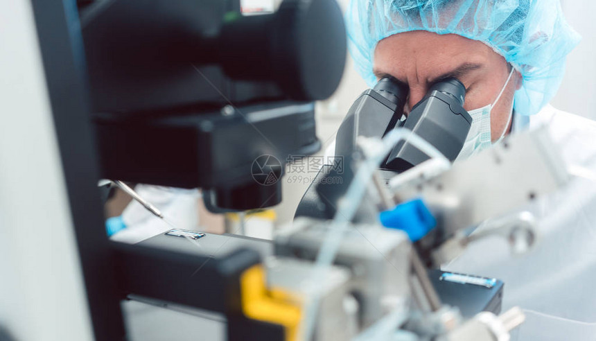 医生或科学家通过生物技术实验室的显图片