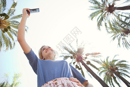 在一个年轻的旅游妇女举起她的手臂图片
