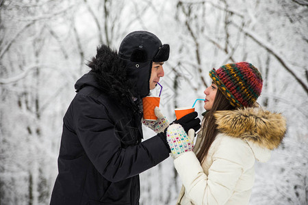 冬天一对幸福的夫妇在户外一起喝红茶图片