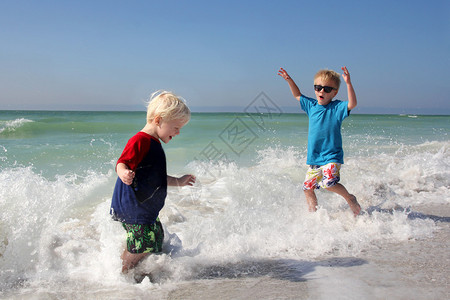 两个快乐的小孩在沙滩上玩耍图片