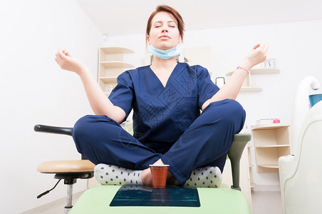 用瑜伽和莲珠姿势冥想的牙医妇女咖啡休息和放松作为医图片