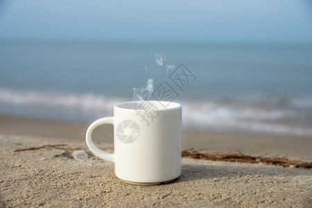 海滩上的白咖啡杯图片