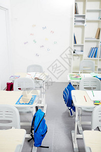 在空教室内两排配有学校用品的桌图片