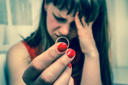 悲伤的女人拿着结婚戒指离婚概图片