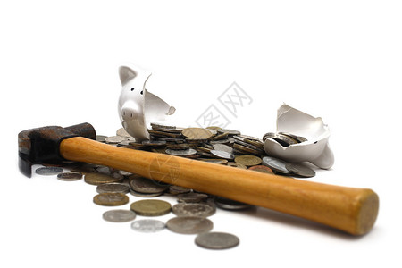 一个破碎的小猪银行孤立在白色背景上带着来自世界各地的硬币和锤子图片