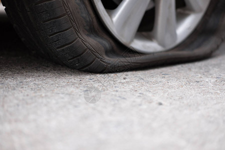 由于钉子敲击导致汽车轮胎泄漏路上轮胎瘪了压扁刺破的汽车轮图片