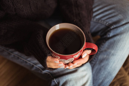 拿着一杯红茶的漂亮指甲的女人图片