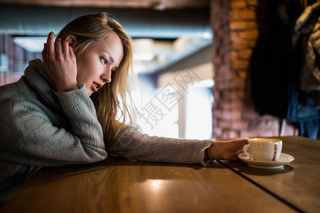 美丽的微笑女人在咖啡馆喝咖啡图片
