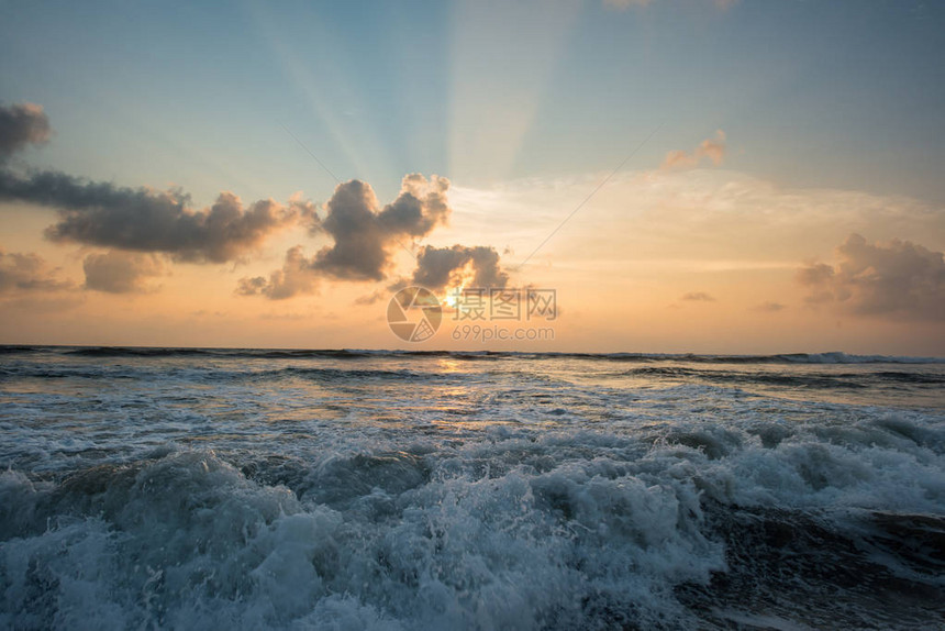 热带岛屿上波涛汹涌的大海的美丽日落图片