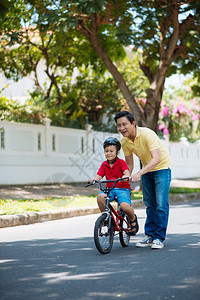 快乐的越南男孩在父亲的帮助下学图片
