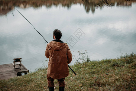 渔夫在湖上用竿钓鱼的后视图图片