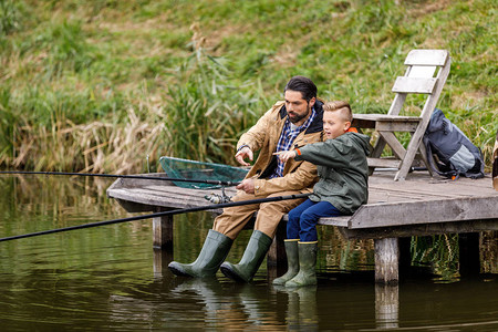 父亲和儿子在湖边木头码与图片
