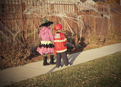 两个穿着万圣节服装的孩子在附近走动挨家户图片