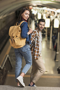 在地铁站背着包的时尚情侣图片