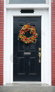 黑色前门上的秋天花环图片
