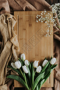 国际妇女日木板和桌布上的白色郁金香的顶部视图图片