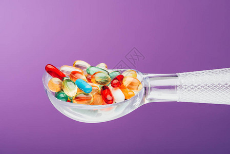 用紫色隔离的勺子近距离观察药物背景图片