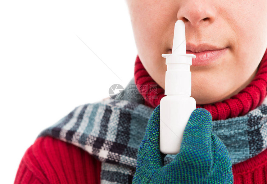 冷酷妇女用鼻喷剂或将喷雾贴近鼻子图片