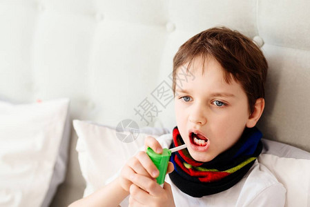小男孩用喷雾吸入器吸入他的喉咙图片