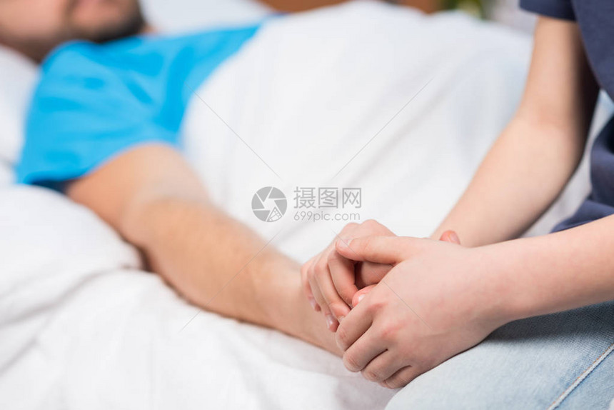 近视部分是儿子与生病父亲的手握在医院床上父亲和图片