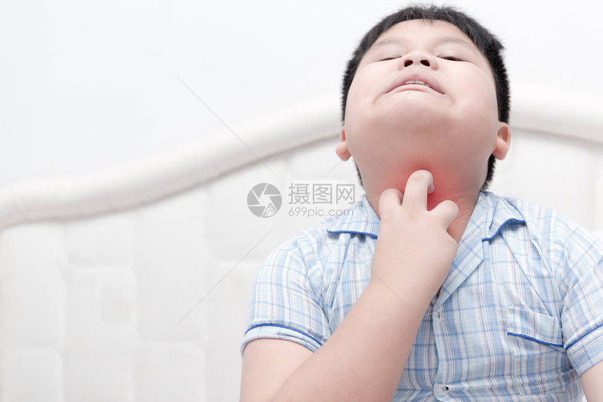 亚述肥胖的男孩用手抓痒在床上与医疗和医图片