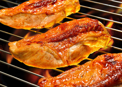 火焰状烤架上的烤鸡胸肉图片