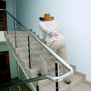 老人背痛拄着拐杖爬楼梯图片