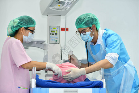 亚洲男妇产科医生和护士正在医院对新生儿进图片