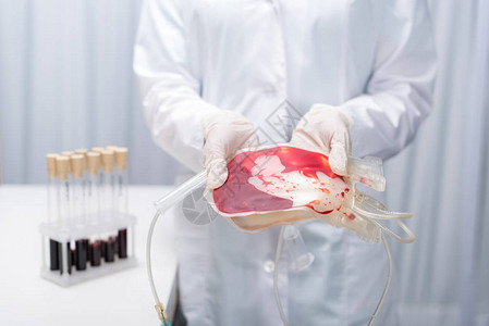 持有输血医疗设备的实验室大衣医生被射伤图片