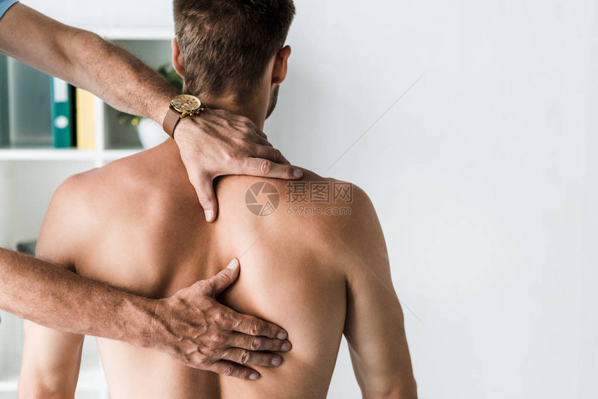 医生抚摸光着膀子病人背部的剪影图片