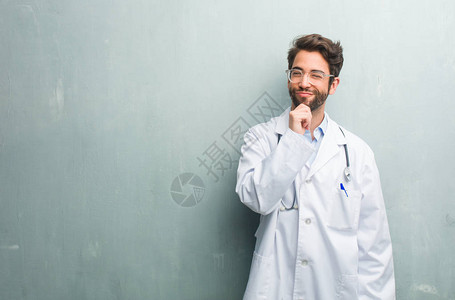 年轻友好的医生靠在格朗基风的墙上图片