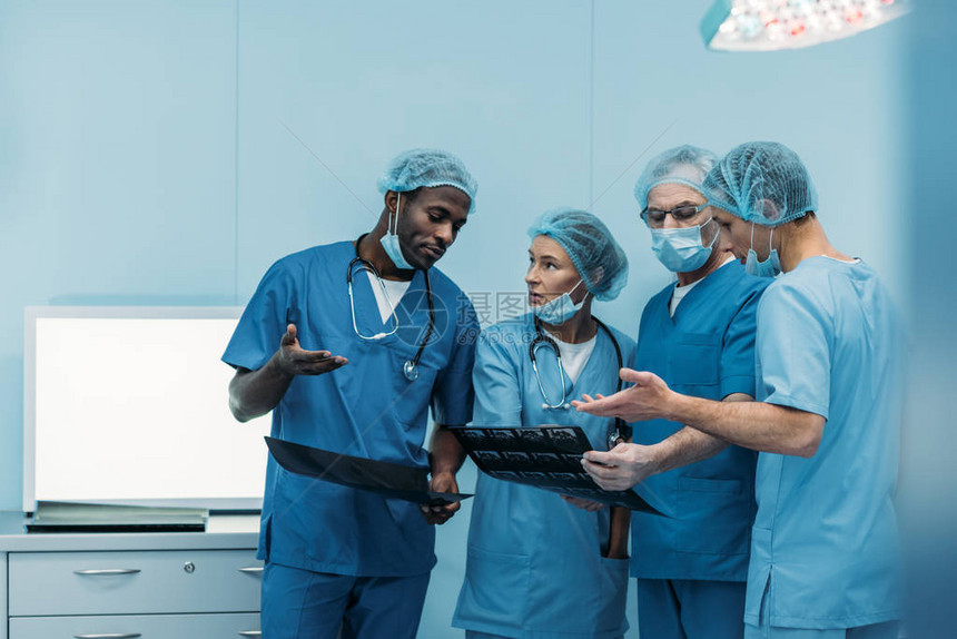 4名多族裔外科医生在手术室谈论图片