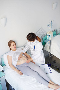 孕妇躺在医院的床上而医生抚图片