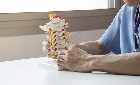 医生向医务室的病人演示子宫颈脊椎模型图片
