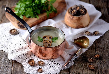 健康的蘑菇奶油汤用老木质的菜和面食煎饼图片