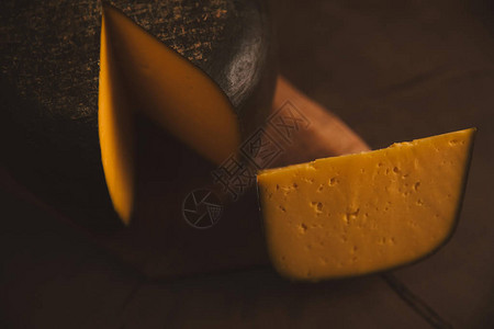 木质表面切片奶酪的特写镜头图片