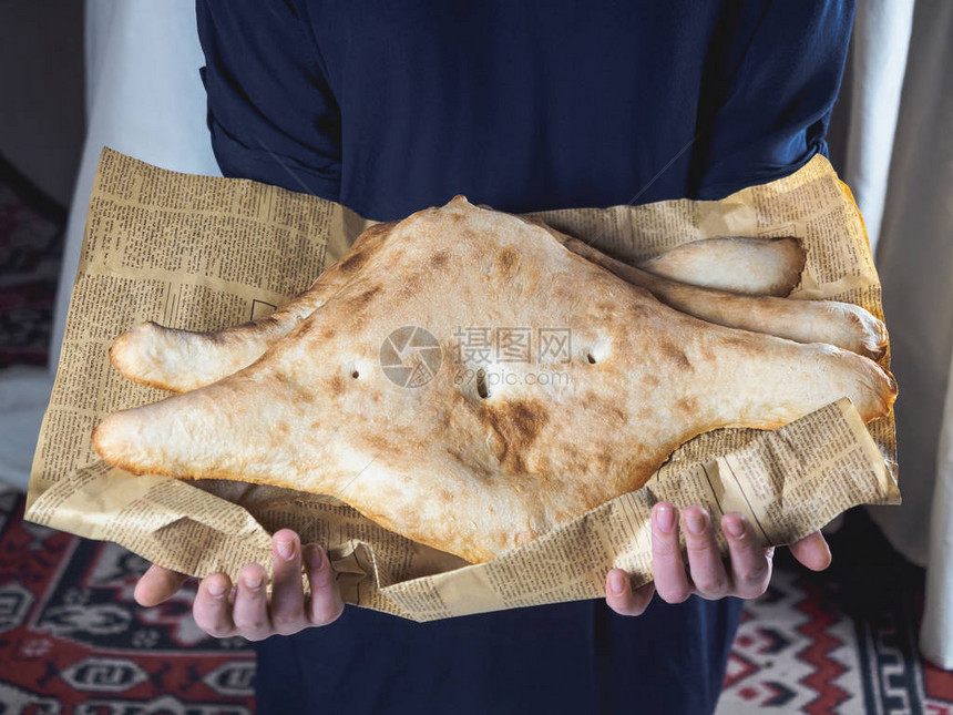 报纸上持有美味的传统格罗吉亚传统扁面包的图片