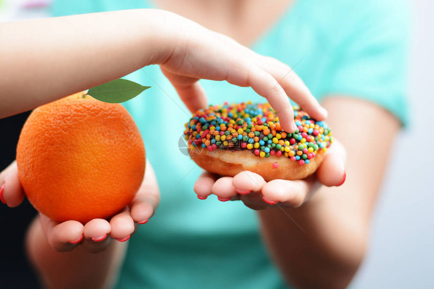 儿童肥胖概念与小女孩手选择甜而不健康的甜图片