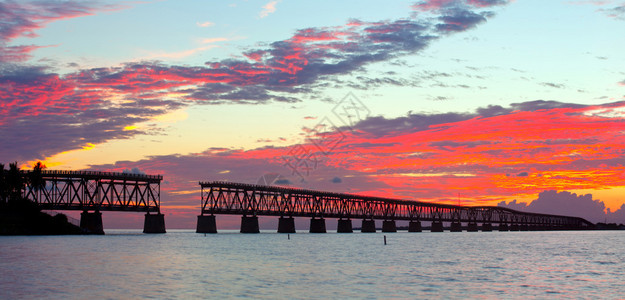 美丽的热带日落或日出的多彩景观拍摄于佛罗里达州的巴伊亚本田基州立公园老弗拉格勒桥仍然是旅游地标背景图片