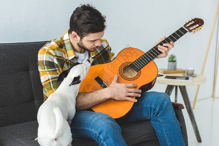 英俊男人玩音响吉他和狗一图片