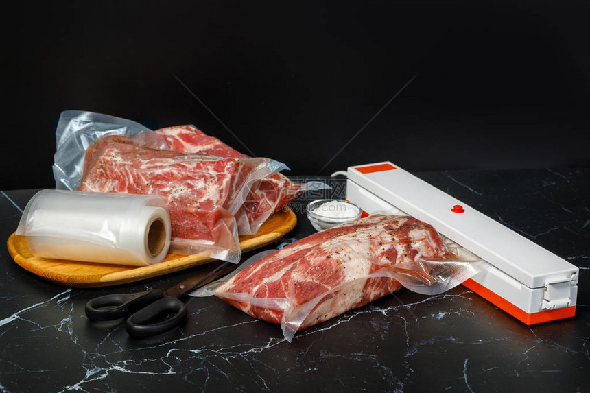 真空封口机和深色背景上的肉图片
