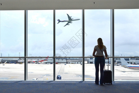 机场窗口的女孩背景图片