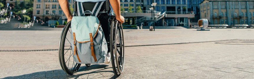 在街上使用带包的轮椅的人裁剪全景图片