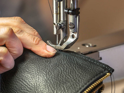 缝衣机在车间操作时用手制衣服高清图片