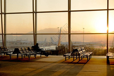 坐在大厅机场等待飞行的乘客使用手机在休图片