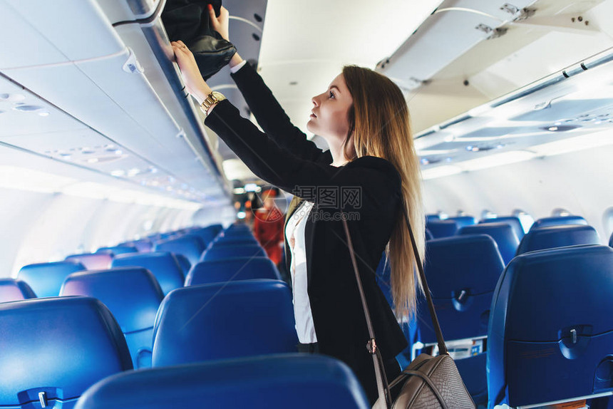 女学生用飞机把她的手提行李放在图片