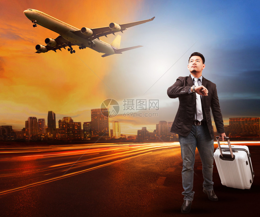 年轻人和旅行包李站在城市道路上仰望天空和飞机往机场跑道用于图片