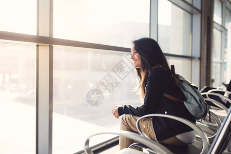 年轻女子坐在机场等她的飞机图片