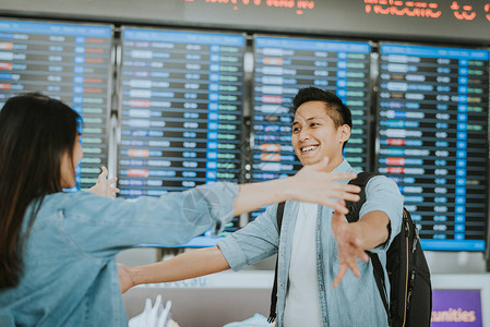 快乐的亚洲女人在她男朋友从国外返回机场后图片
