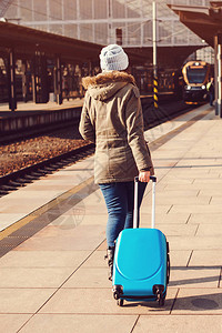 拖着行李箱包火车站的女孩旅程概念生活方式图片